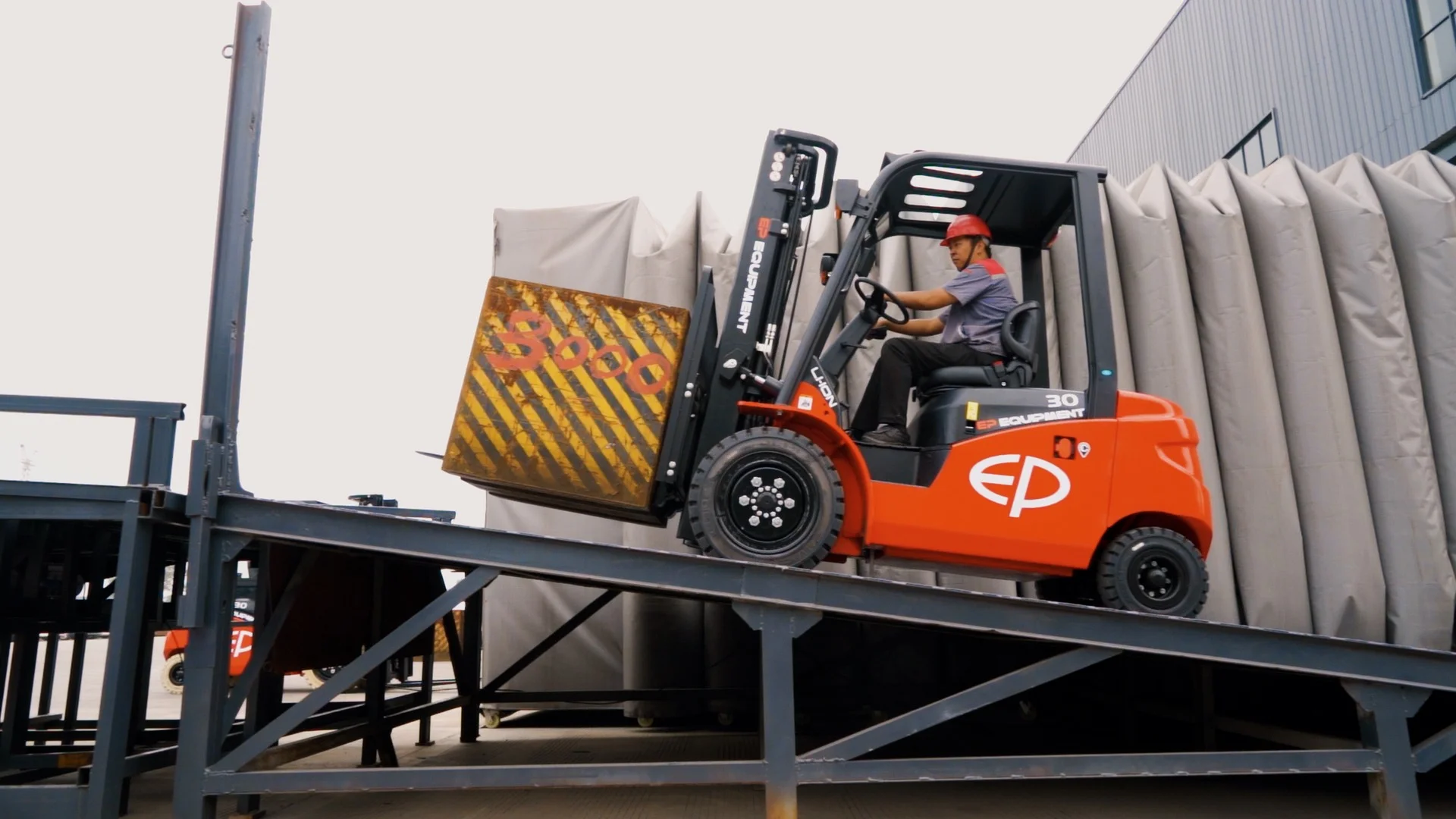 EFL303 lithium counterbalance forklift driving up ramp with loaded pallet outside warehouse facility
